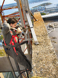 [Photo: Johnathan Thibodeau on the Fenwick Place roof Sept. 2005]
