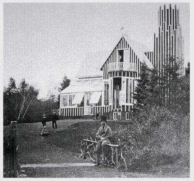 (Image: Andrew Downs sits on a fence rail near the
 Glass House)