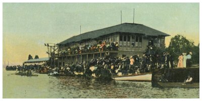 (Image: Crowds Fill the Verandah and Shoreline Overlooking
  the Water)