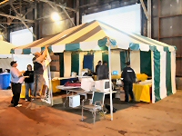 [Photo: HRCA and CCN volunteers setting up the tent.] 