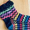 Zigzag Socks knit in jewel tones on black background.