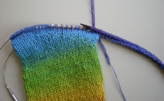 On Needle A the working yarn is knit across the first half of the sleeve stitches