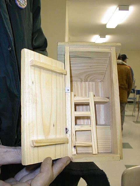 [The inside of the outhouse showing two seats with holes, one above
the other with a stepladder to reach the top one.]