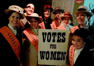 (Image: The Cast Gatherd around a `Votes for Women' Sign)