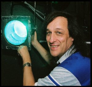 (Image Right: Richard Smiles at the Camera as
 he Focuses a Light)