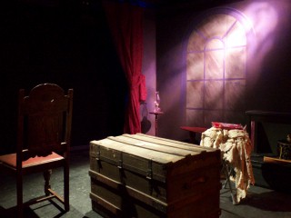(Image: A Room with a Chest, Chair and Other Objects Dramatically
 Lit, with a Window in Behind Illuminated by a Lavendar Shape of Light)